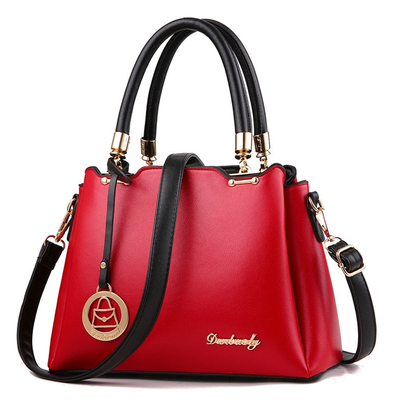 Red women’s handbag with top handles, gold-tone hardware, and crossbody strap