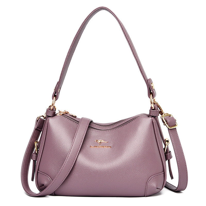Women’s one-shoulder messenger bag in mauve soft leather with gold-tone hardware.