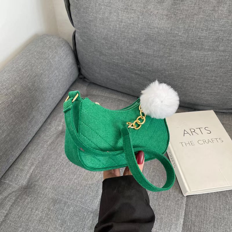 Green felt crossbody bag with gold chain and white pom-pom keychain