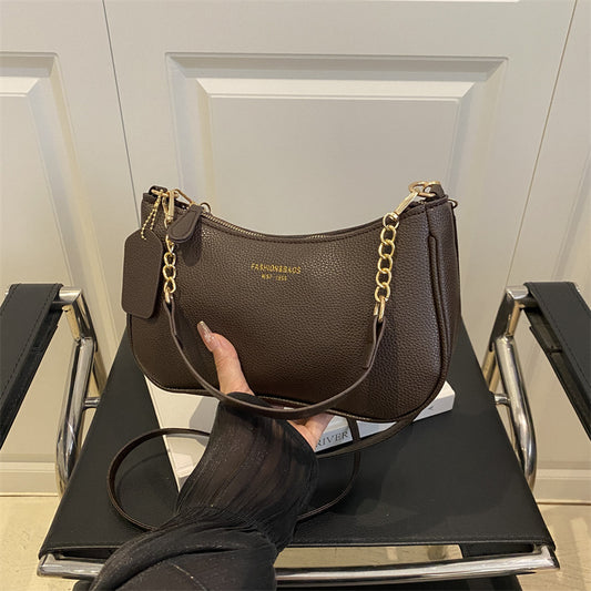 Black pebbled leather-look shoulder crossbody bag with gold chain straps and top zipper