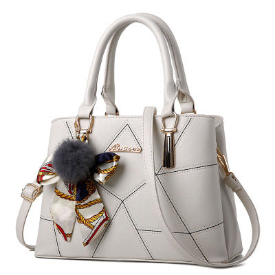 White quilted top-handle handbag with adjustable crossbody strap and charm detail