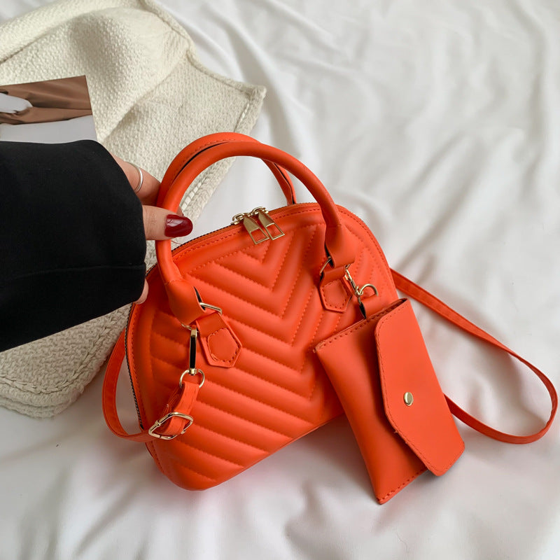 Orange quilted mini messenger bag with gold hardware and front crossbody strap