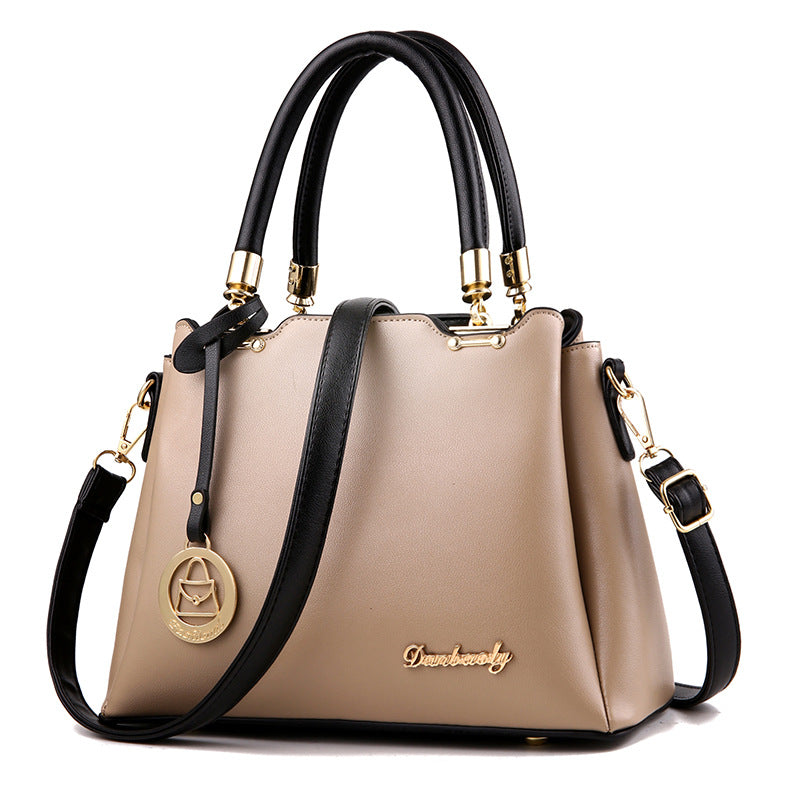 Beige women’s handbag with top handles, gold-tone hardware, and crossbody strap