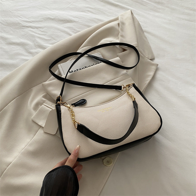 Cream pebbled shoulder crossbody bag with black strap accents and gold chain detail