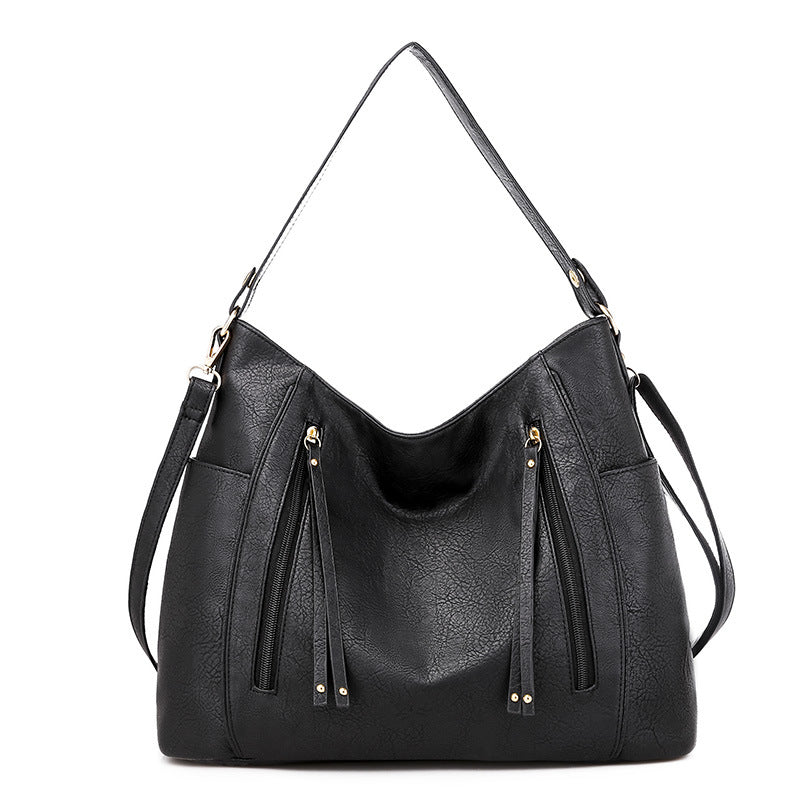 Women's black shoulder hobo bag with curved top and two front zipper pockets