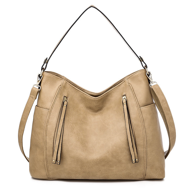 Women's beige shoulder hobo bag with curved top and two front zipper pockets