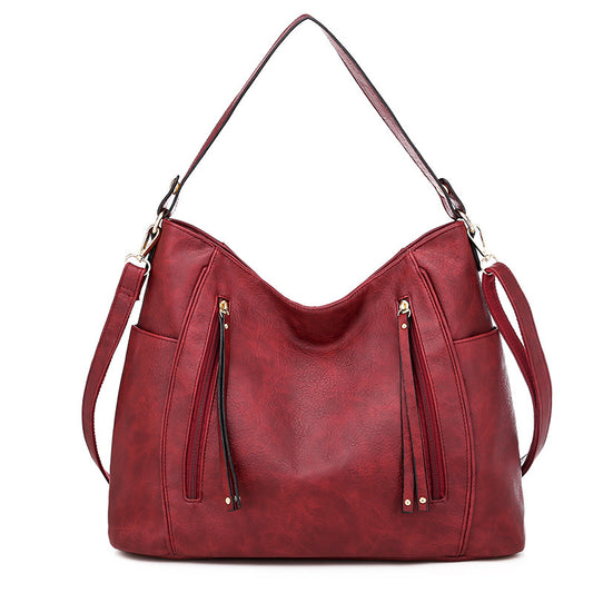 Women's red shoulder hobo bag with curved top and two front zipper pockets