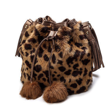 Leopard-print faux-fur drawstring bucket bag with tassels and two pom-pom feet