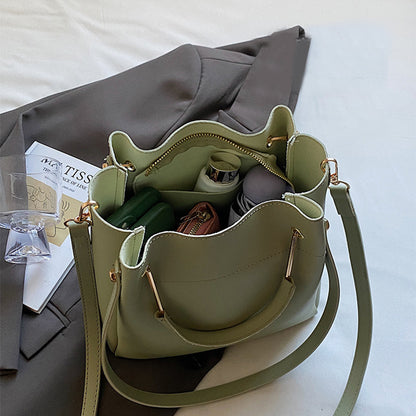 Olive green bucket bag with open top showing inner compartments and drawstring cord