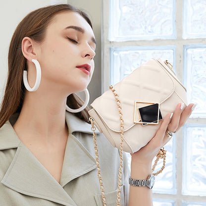 White leather crossbody bag with chain strap and square black front emblem