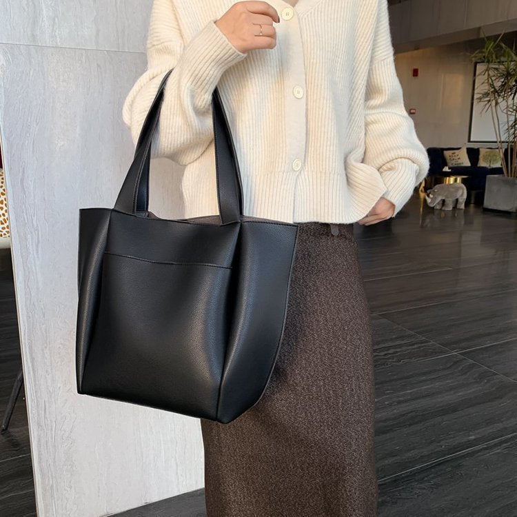 Black large-capacity tote handbag with two top handles, smooth textured finish