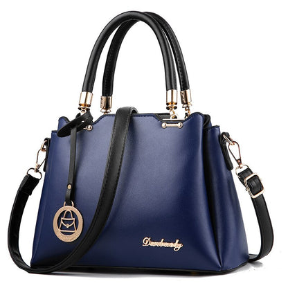 Deep blue women’s handbag with top handles, gold-tone hardware, and crossbody strap