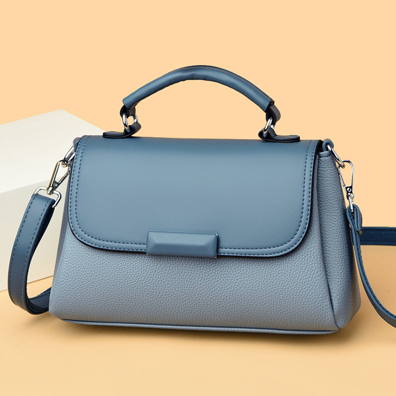 Blue women’s flap handbag with textured finish, top handles, and crossbody strap