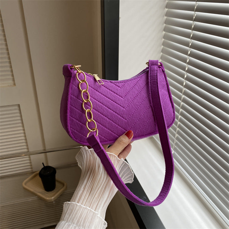 Purple felt crossbody bag with gold chain strap and quilted chevron design