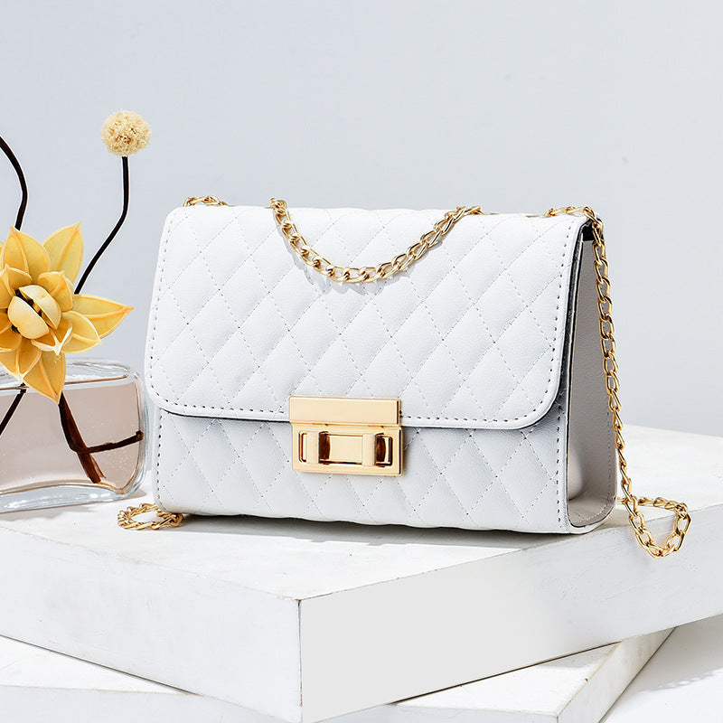 White quilted mini square crossbody bag with gold chain and front turn-lock