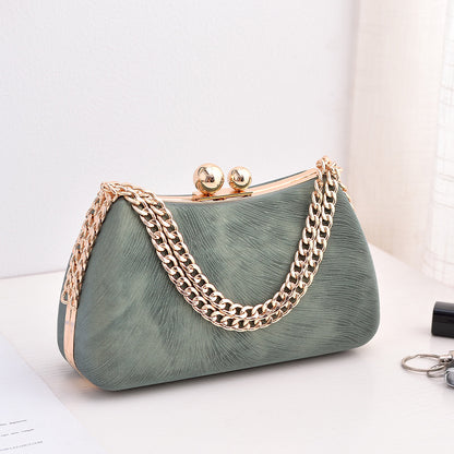 Green textured clutch bag with gold-tone chain shoulder strap and kiss-lock clasp