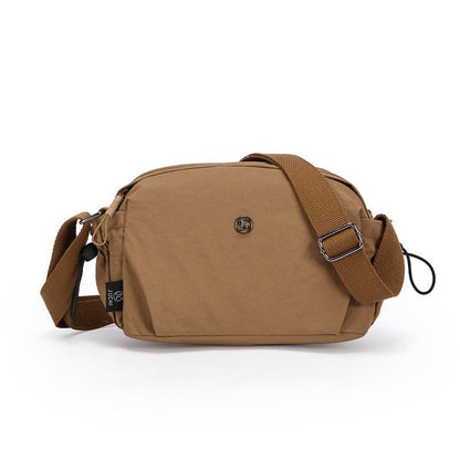 Small brown nylon crossbody bag with adjustable strap and zip closure