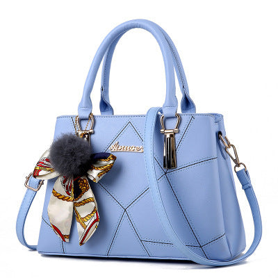 Light blue quilted top-handle handbag with adjustable crossbody strap and charm