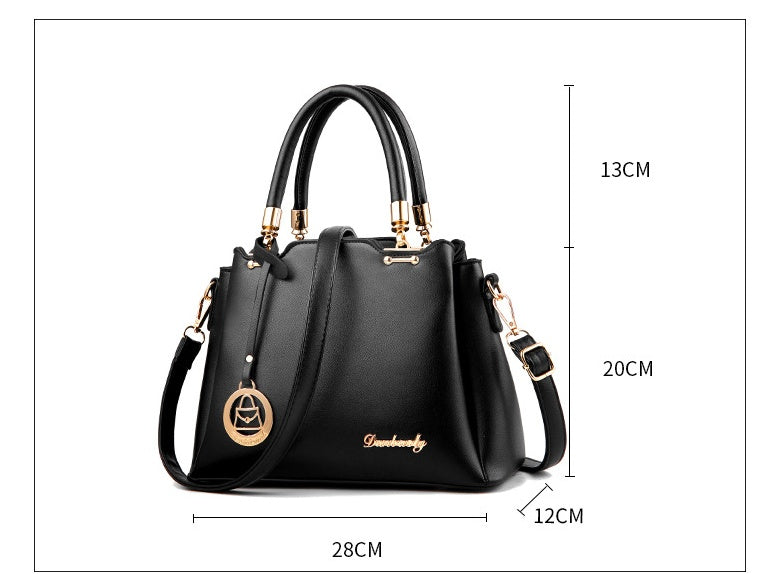 Black women’s handbag with top handles and crossbody strap, front view