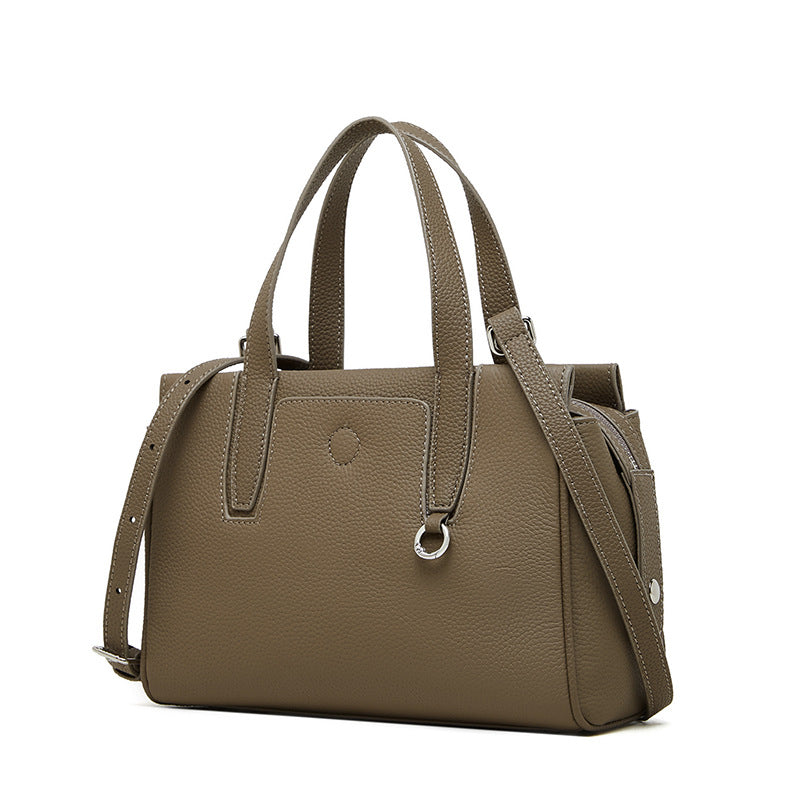 Taupe leather crossbody bag with double top handles, adjustable strap, and front pocket