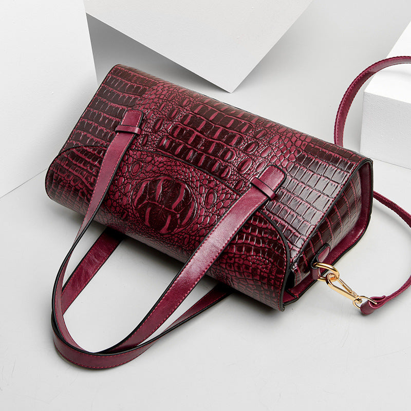 Deep red croc-pattern crossbody bag with front flap and adjustable shoulder strap