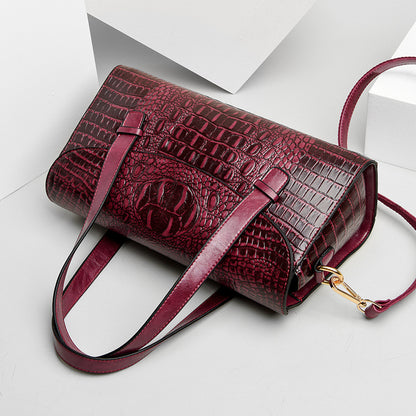 Deep red croc-pattern crossbody bag with front flap and adjustable shoulder strap