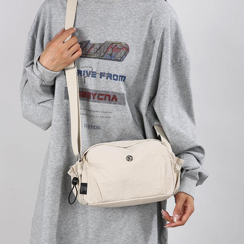 Small off-white nylon crossbody bag with adjustable strap and zip closure