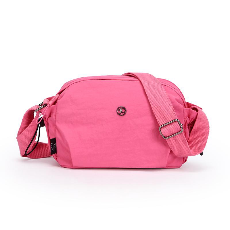 Small pink nylon crossbody bag with adjustable strap and zip closure