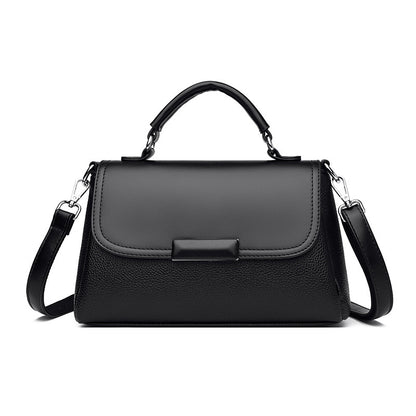 Black women’s flap handbag with top handle, buckle detail, and shoulder strap