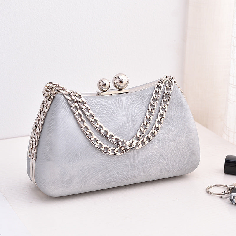 Silver textured clutch bag with silver-tone chain shoulder strap and kiss-lock clasp