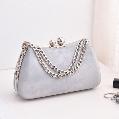 Silver textured clutch bag with silver-tone chain shoulder strap and kiss-lock clasp