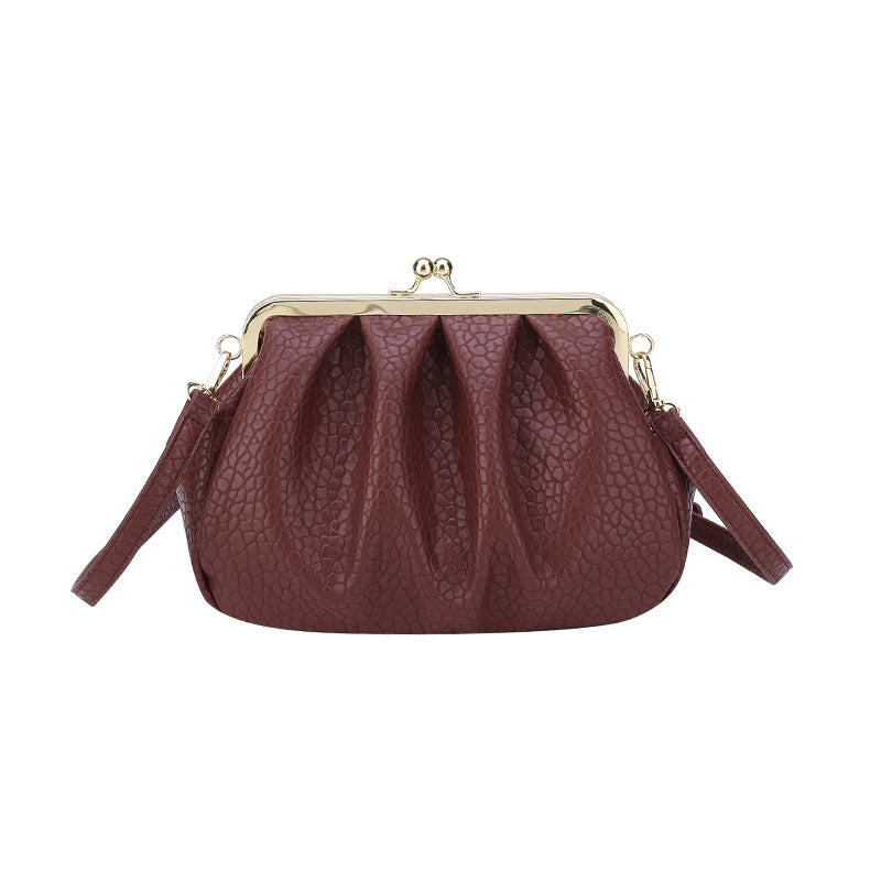 Burgundy textured clutch-style handbag with kiss-lock frame and side straps