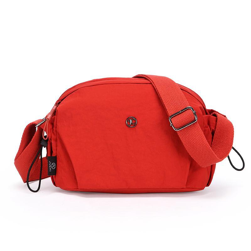 Small red nylon crossbody bag with adjustable strap and zip closure