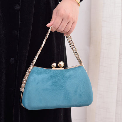 Blue crossbody clutch bag with gold-tone chain strap and kiss-lock clasp