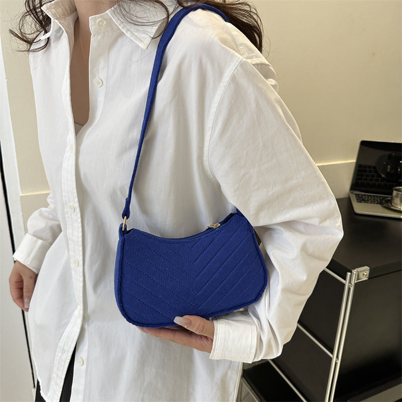 Blue felt crossbody bag with quilted pattern and adjustable shoulder strap