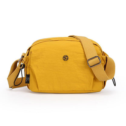 Small mustard yellow nylon crossbody bag with adjustable strap and zip closure