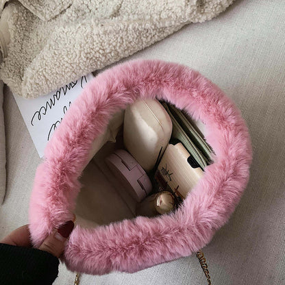 Pink plush mini shoulder bag open at top, showing small items inside