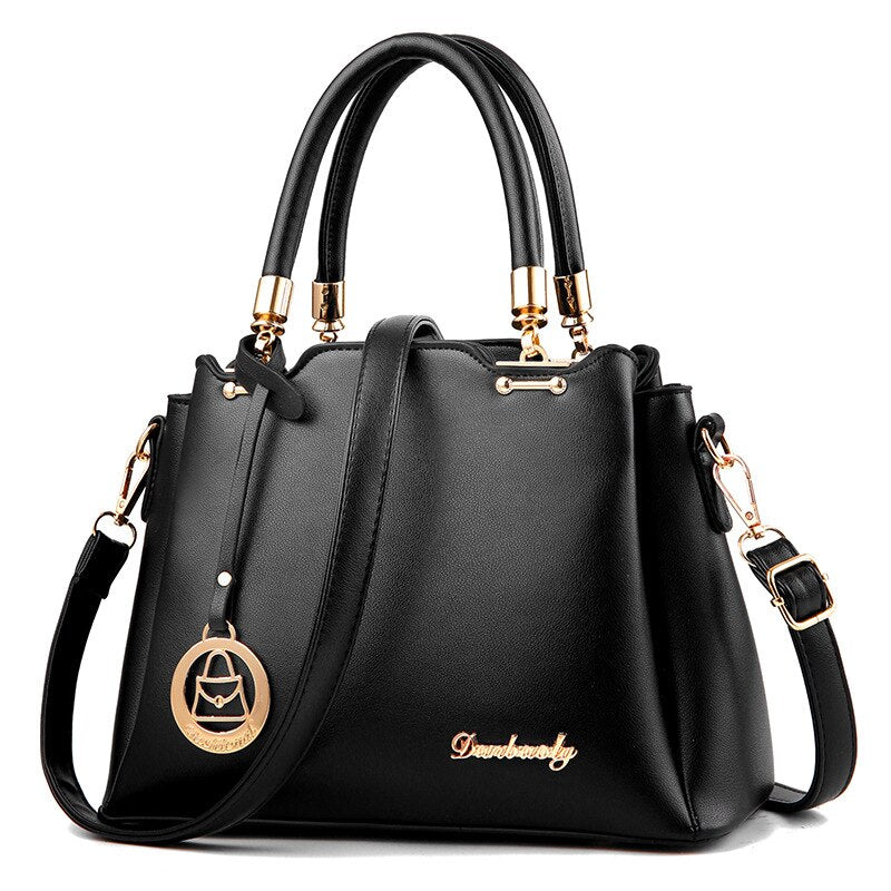 Black women’s handbag with top handles, gold-tone hardware, and crossbody strap