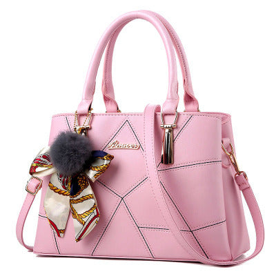 Blush pink quilted top-handle handbag with adjustable crossbody strap and charm