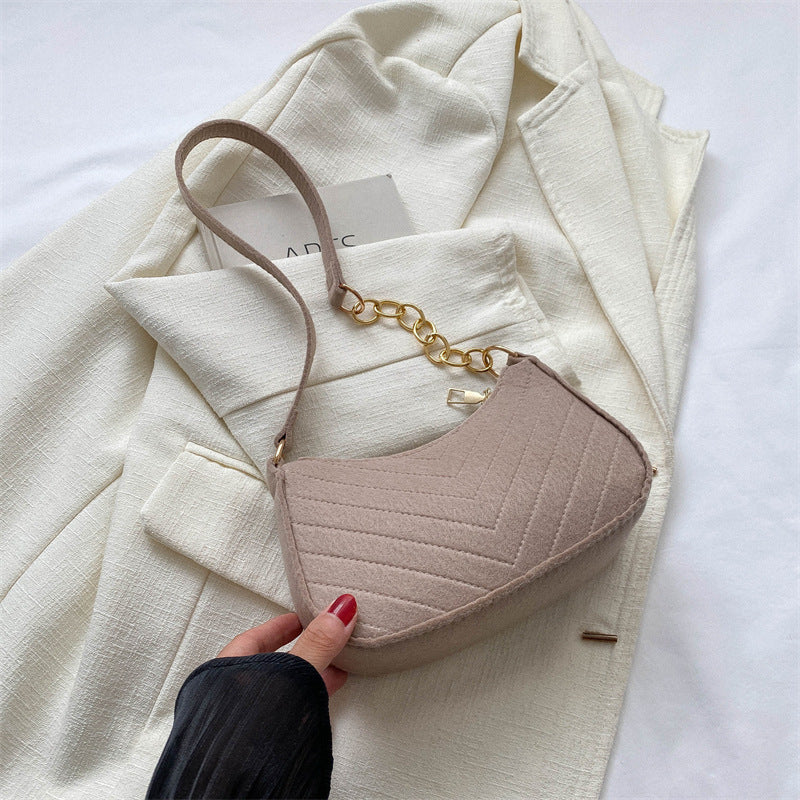 Cream felt crossbody bag with gold chain strap and brown adjustable shoulder strap