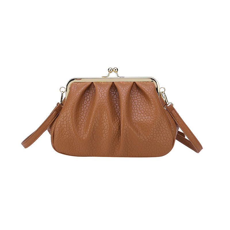 Tan textured clutch-style handbag with kiss-lock frame and side straps
