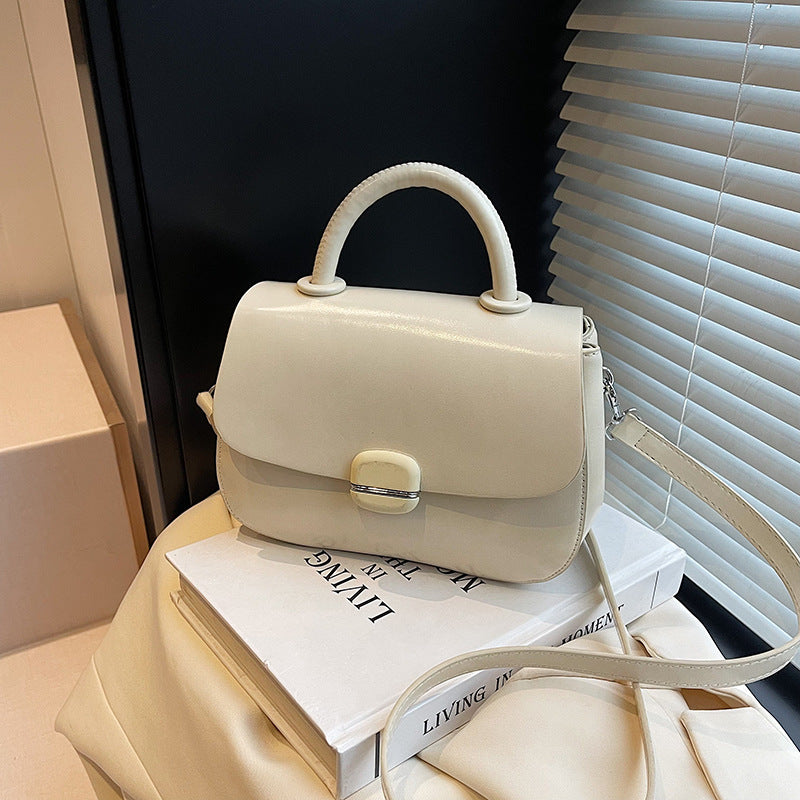Off-white double-layer crossbody handbag with top handle, flap front, and shoulder strap