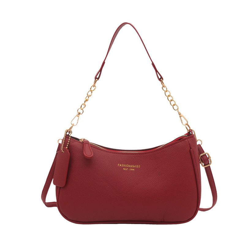 Burgundy pebbled shoulder crossbody bag with gold chain handles and side tassel