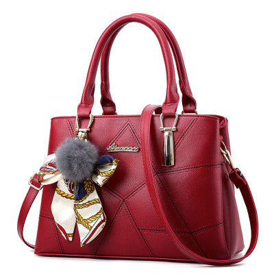 Red quilted top-handle handbag with adjustable crossbody strap and bow charm