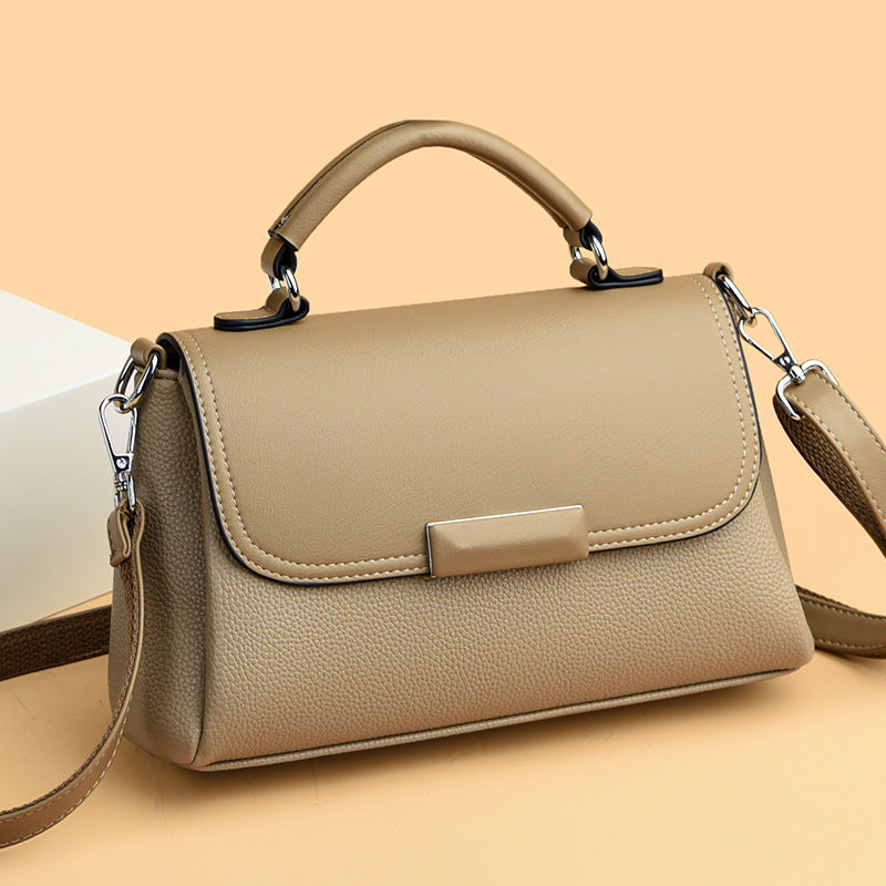 Light beige women’s handbag with front flap and rectangular clasp, with shoulder strap
