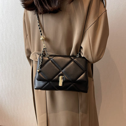 Black quilted diamond messenger bag with gold chain strap and front bar lock