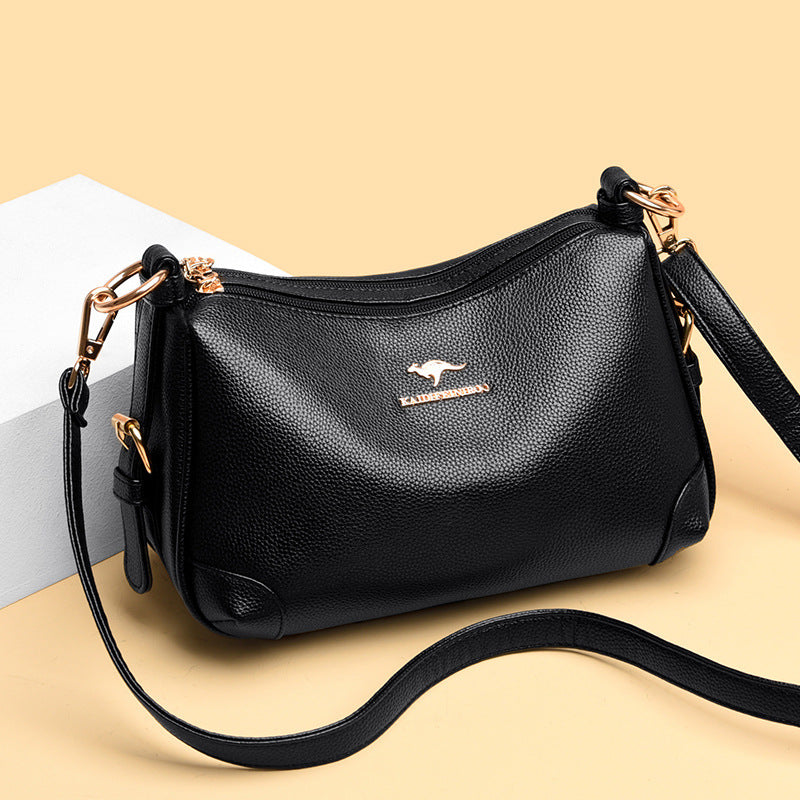 Black soft leather one-shoulder messenger bag with zipper top and gold-tone hardware.