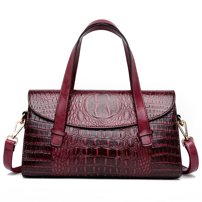 Burgundy croc-pattern hand carry shoulder bag with top handles and side crossbody straps