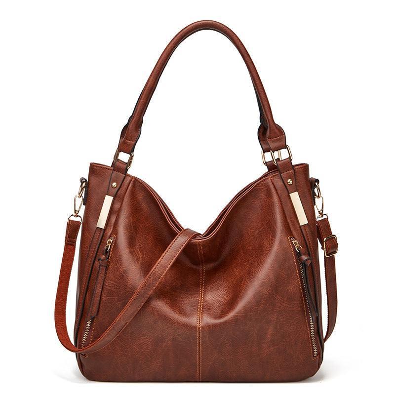 Brown leather-look tote shoulder bag with curved silhouette and zippered side pockets