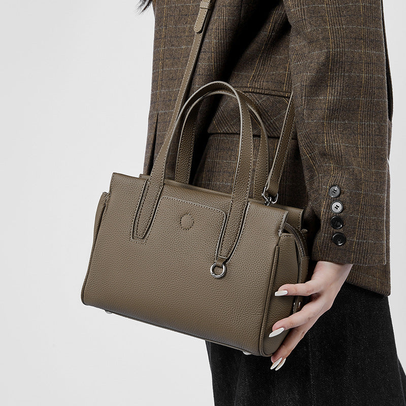 Structured taupe crossbody bag with top handles, front pocket, and zipper closure